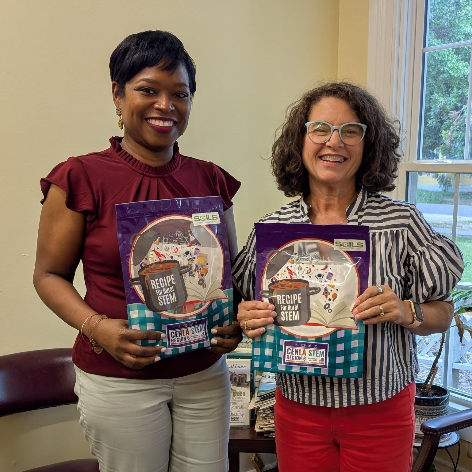 Two women holding a package of supplies.